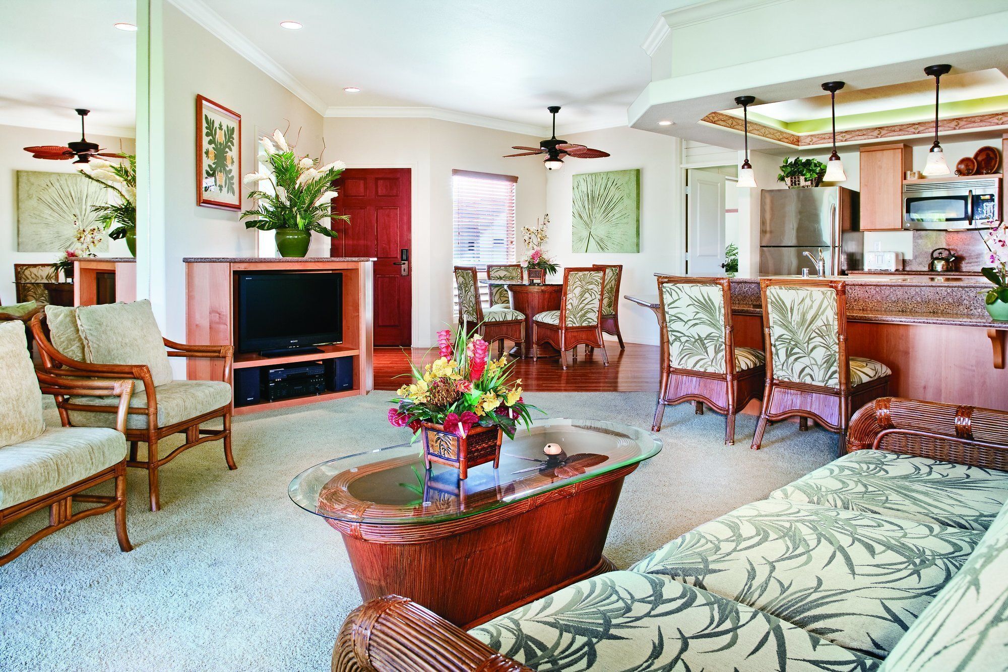 A spacious living room with a television, comfortable seating, and a dining area with chairs and a table.