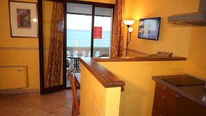 Een keuken met uitzicht op zee, een eethoek en een kleine bar.