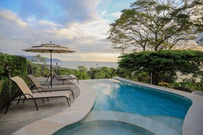 A pool area with lounge chairs and an umbrella, surrounded by lush greenery and overlooking a scenic view. - Best view in Santa Teresa, 2 minutes from the beach beautiful artisan house (Cobano, Santa Teresa Beach)