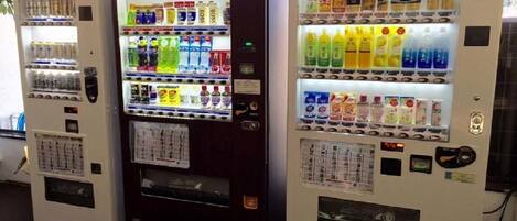 Three vending machines with various beverages and snacks.