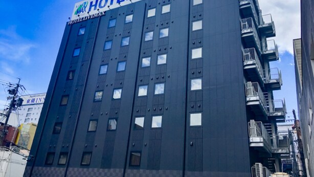 A modern hotel building with a sign reading "HOTEL LIVEMAX." It features a tall structure with multiple windows and balconies. - HOTEL LiVEMAX Yokkaichi-Ekimae (Yokkaichi)