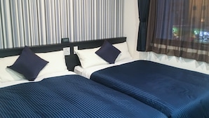 A hotel room with two beds, striped curtains, and a view of a building through sheer curtains. - HOTEL LiVEMAX Yokkaichi-Ekimae (Yokkaichi)