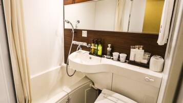 Une salle de bain avec une baignoire, un lavabo, des toilettes et un miroir.