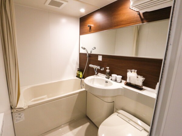 Un baño pequeño con bañera, lavamanos e inodoro.