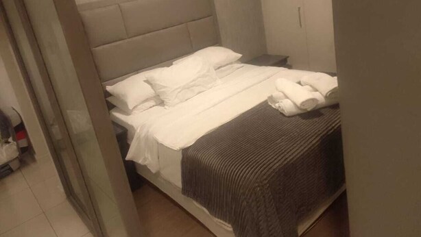 A hotel room with a bed, a nightstand, and a door. - Art Deco Budget Accommodation Rosebank - Hostel (Johannesburg)