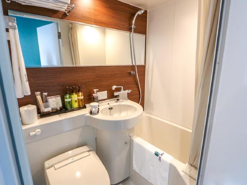 A bathroom with a toilet, sink, and shower.