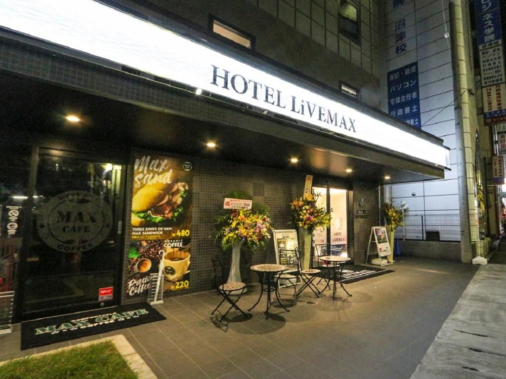 Exterior del Hotel Livemax con un cartel, área de estar al aire libre y un letrero de Max Cafe.