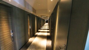 A long, narrow hallway with doors on both sides, leading to individual rooms. - Hotel Livemax Sapporo Susukino (Sapporo)