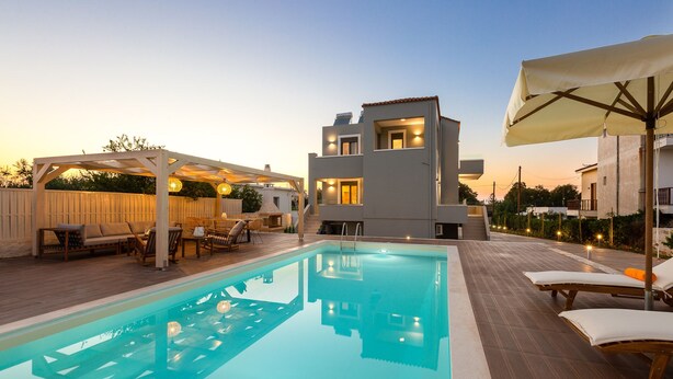 A modern outdoor pool area with a clear pool, lounge chairs, and a pergola with seating. - Anesis Villa, with Private Pool & BBQ, Walking distance to the beach & amenities (Rethymno)