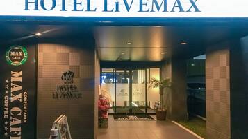 The entrance to HOTEL LIVEMAX with a MAX Cafe sign on the left.