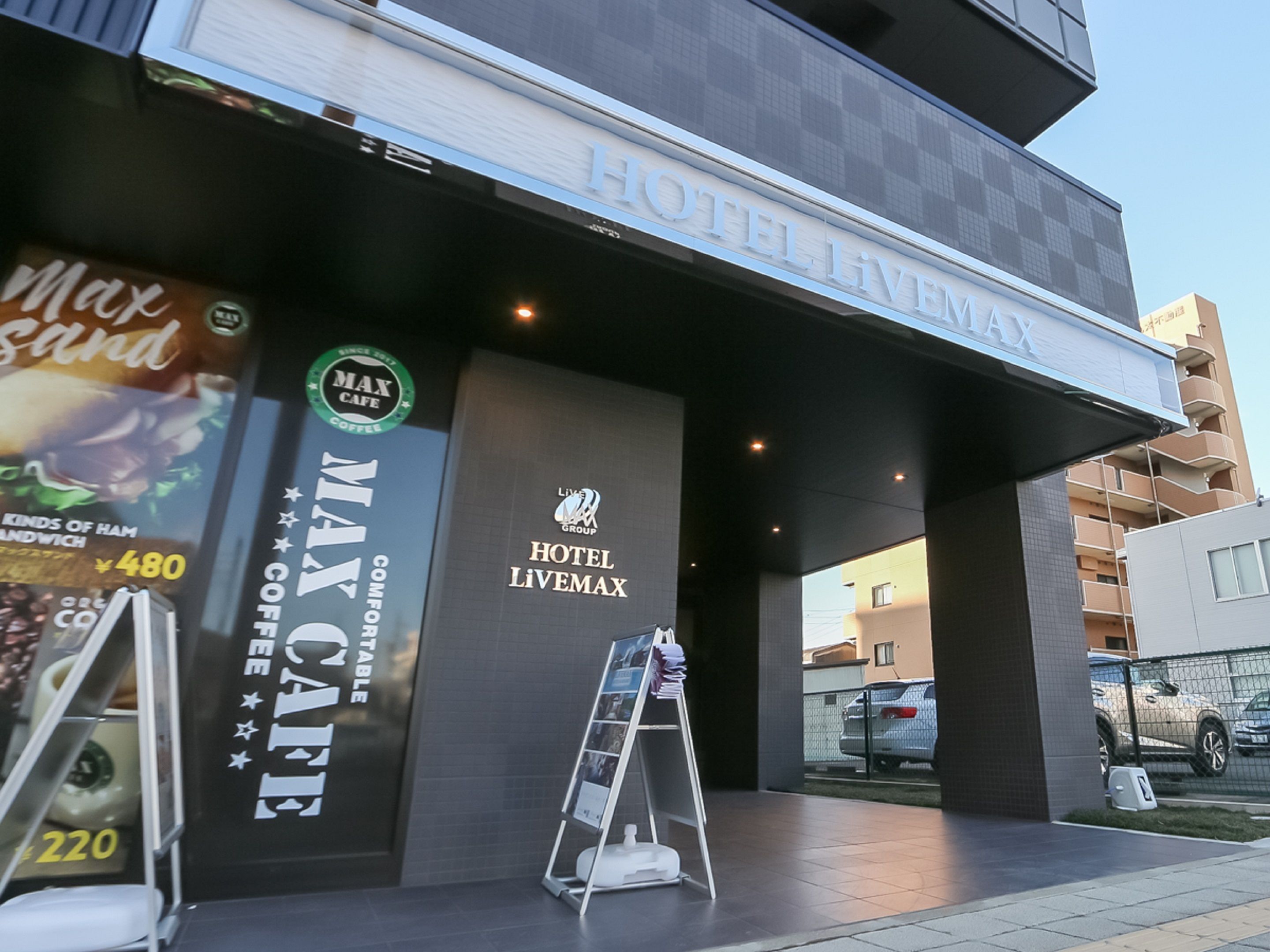 Exterior del Hotel LiVEMAX con un letrero de Max Cafe Coffee.