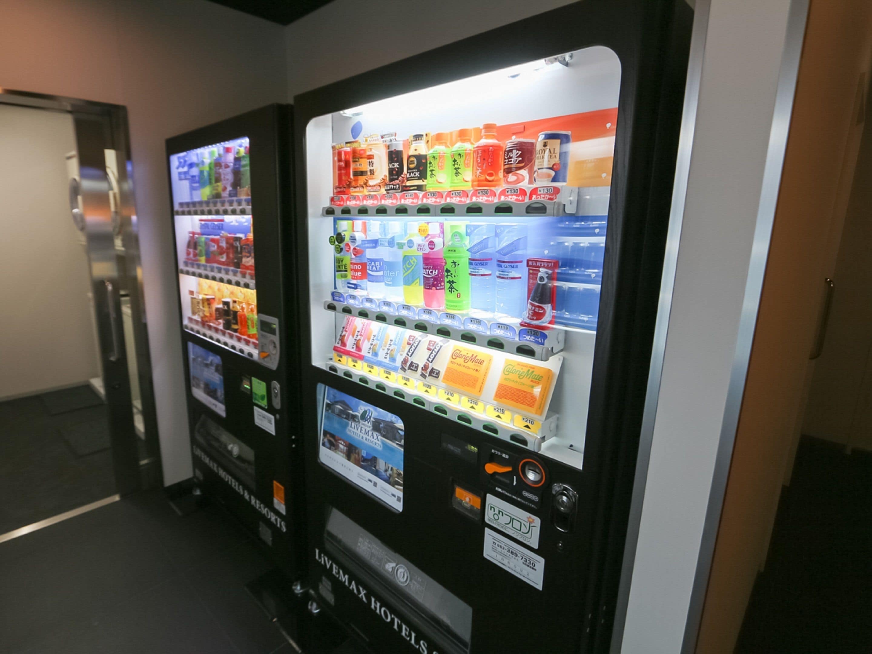 Uma fileira de máquinas automáticas com diversas bebidas e lanches.
