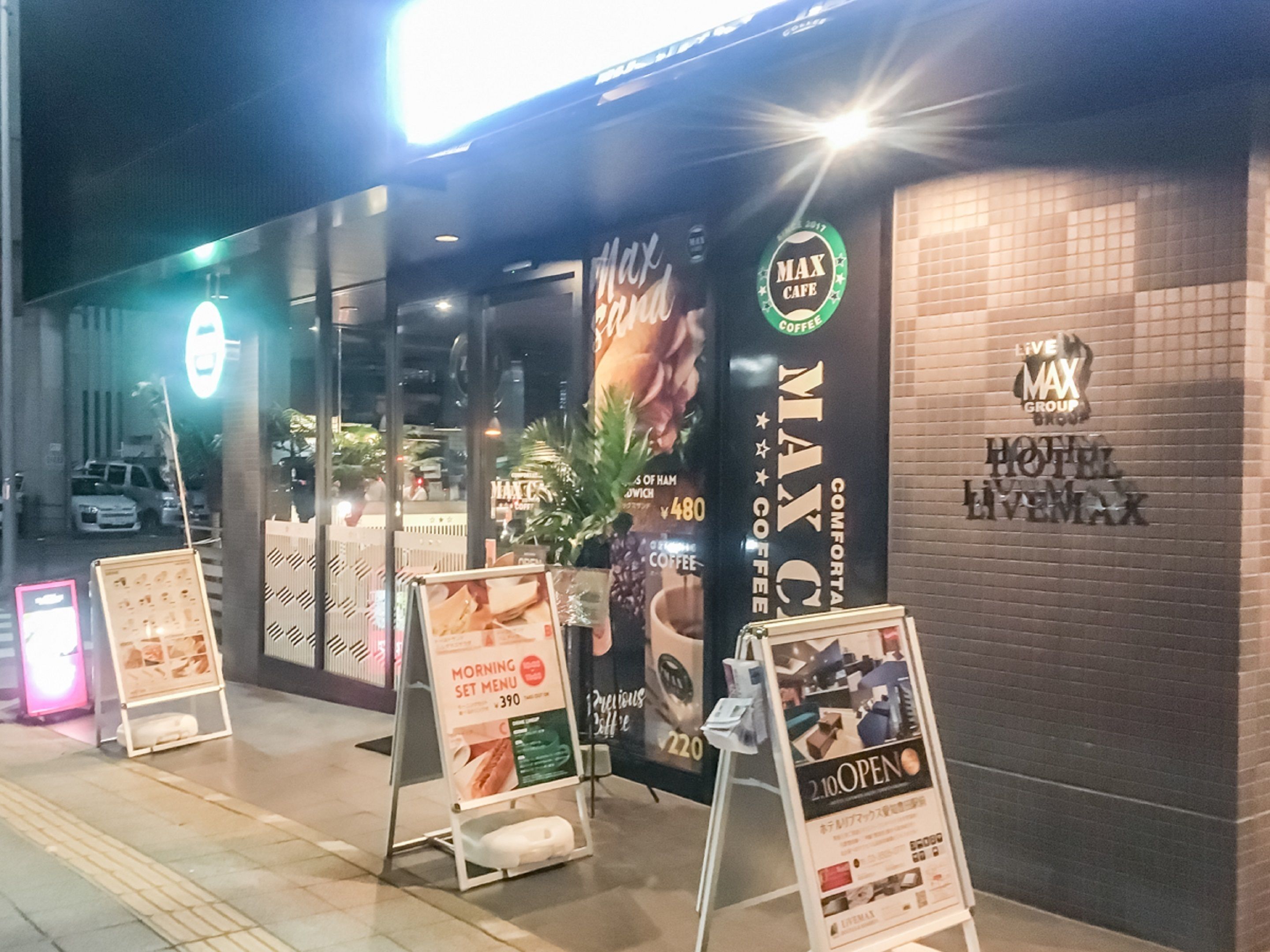 A hotel entrance with a sign for 'Max Cafe' and 'Max Hotel Livemax'.