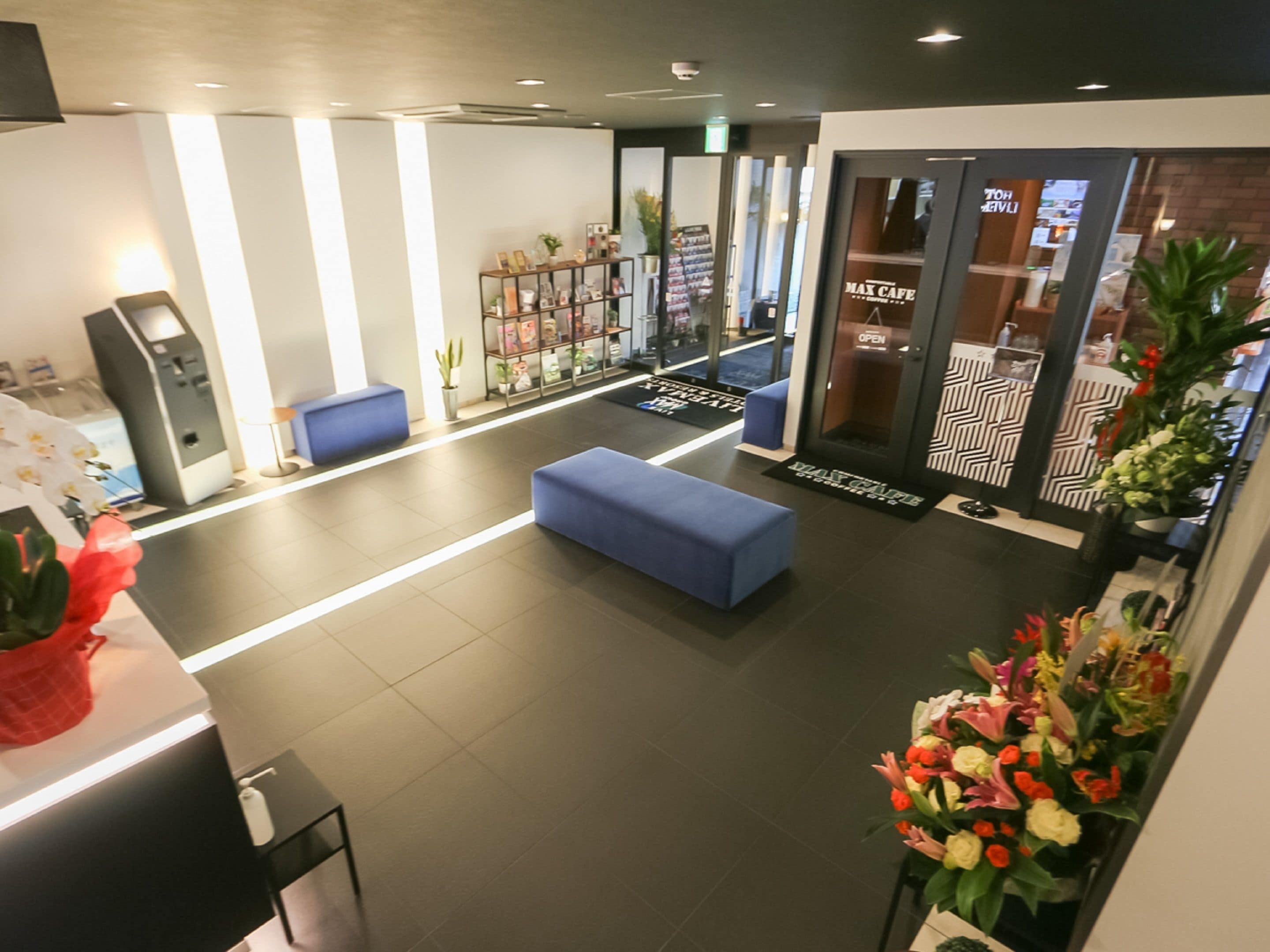 Eine moderne Lobby mit Empfangsbereich, Sitzgelegenheiten und einem Café.