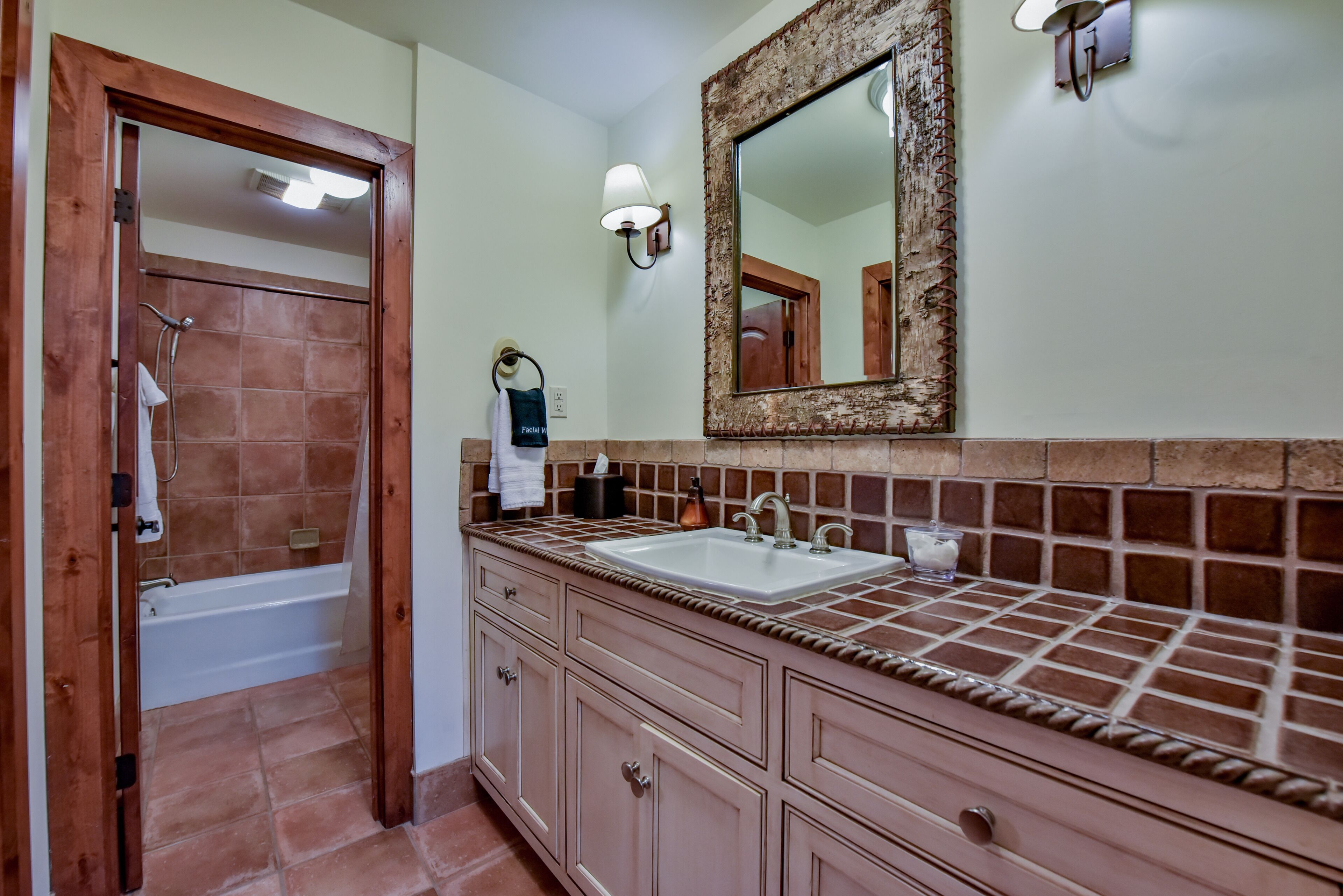 A bathroom with a bathtub, a sink, and a mirror.