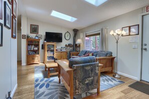 Ein Wohnzimmer mit einer Couch, einem Couchtisch, einem Kamin, einem Fernseher und einem Bücherregal.