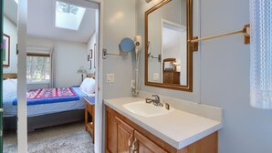 Une chambre à coucher avec un lit, une table de chevet, une lampe et une fenêtre.