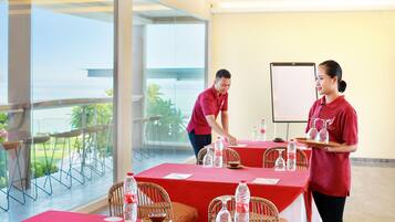 A conference room with tables set for a meeting, equipped with water bottles and glassware.