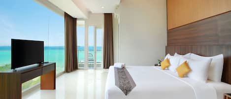 Habitación de hotel moderna con una cama grande, un televisor de pantalla plana y vista al océano.