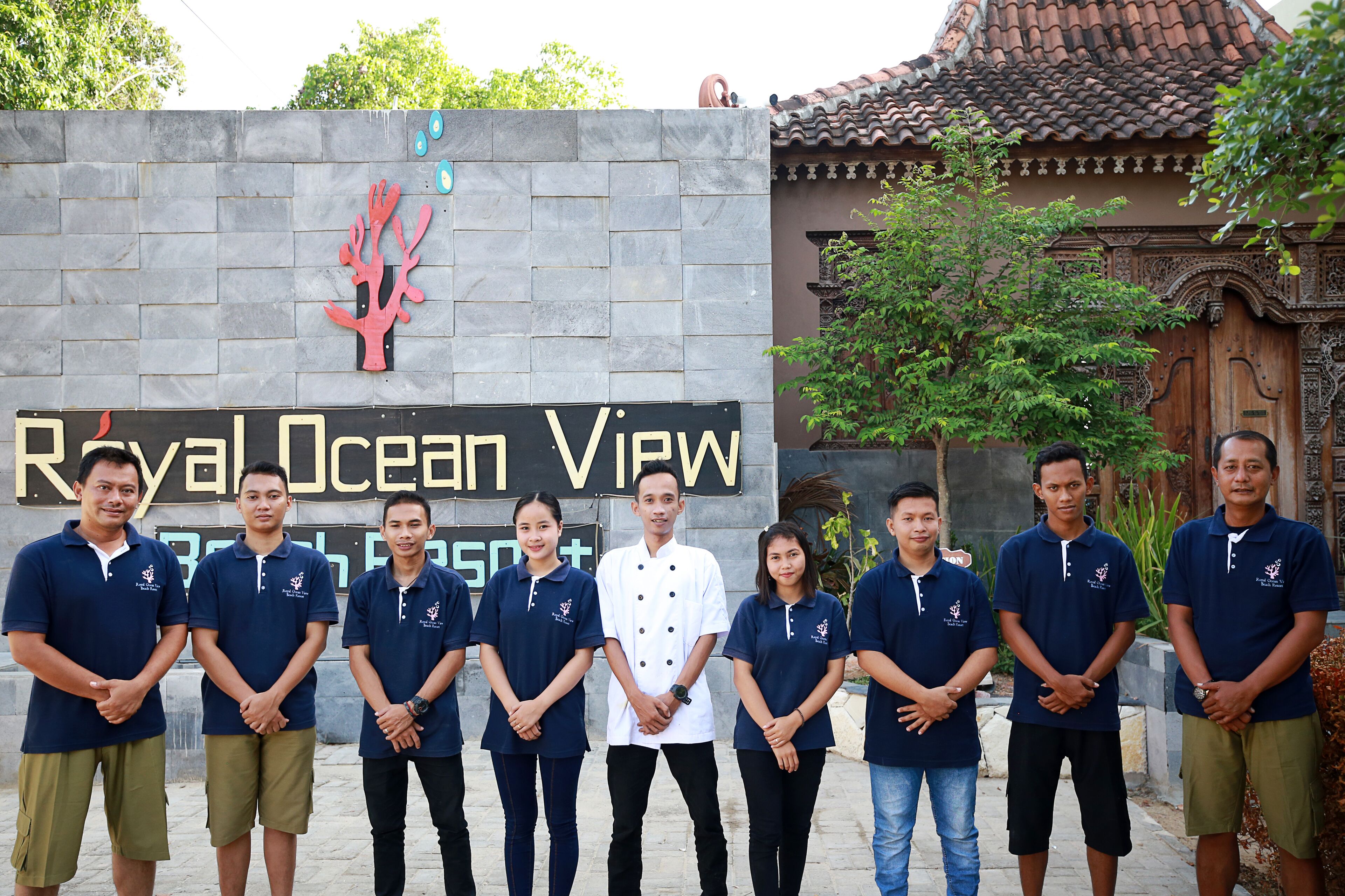 Een groep mensen staat voor een bord waarop 'Royal Ocean View' staat.