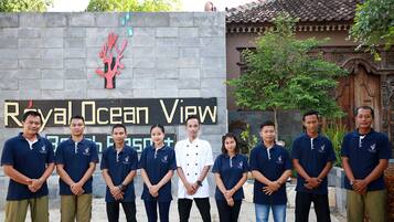 Een groep mensen staat voor een bord waarop 'Royal Ocean View' staat.