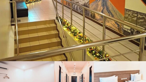 A hotel lobby with a staircase, a reception desk, and a wall with the 'tripinn' logo.