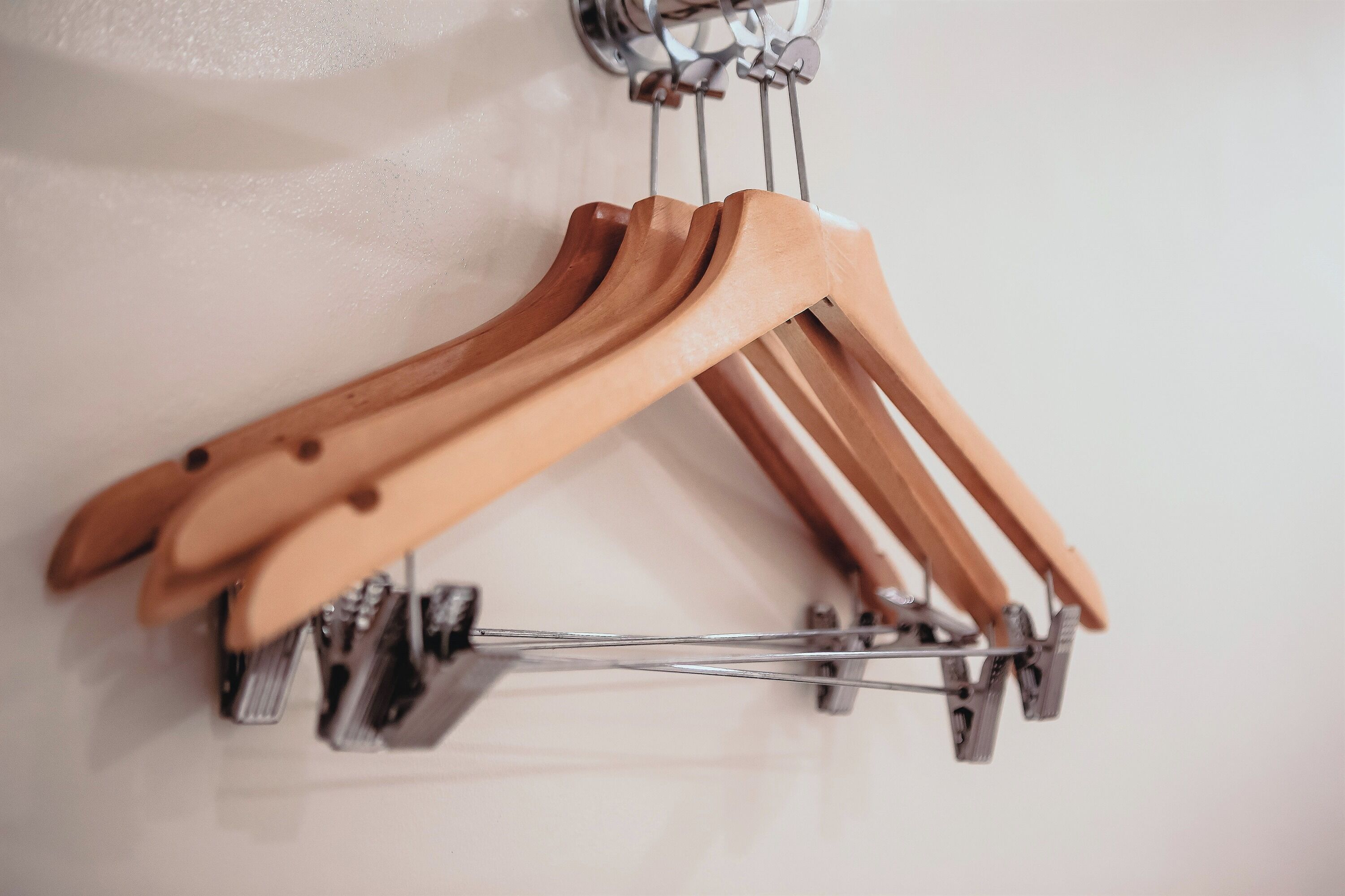 Wooden hangers hanging from a metal rack.