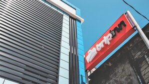 A building with a modern facade, featuring horizontal blinds and a prominent red sign with the name "art inn".