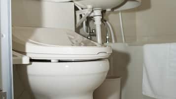 Un baño con inodoro, lavamanos y espejo.