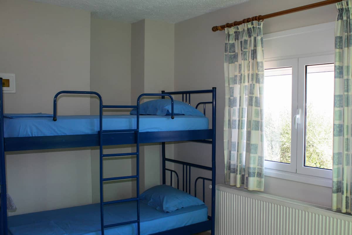 Un dormitorio con literas, una ventana y cortinas.
