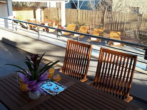Enjoy a romantic meal for two on this serene patio, complete with a beautifully set table and lush greenery.