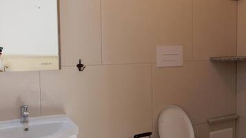 Ein Badezimmer mit Waschbecken, Bidet, Toilette und Spiegel.