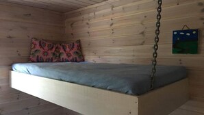 A loft-style bed suspended from the ceiling in a wooden room. - Solferie Holiday Cottage Langenes (Kristiansand)