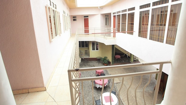 Un immeuble à plusieurs étages doté d’une cour intérieure, de balcons et d’un escalier.