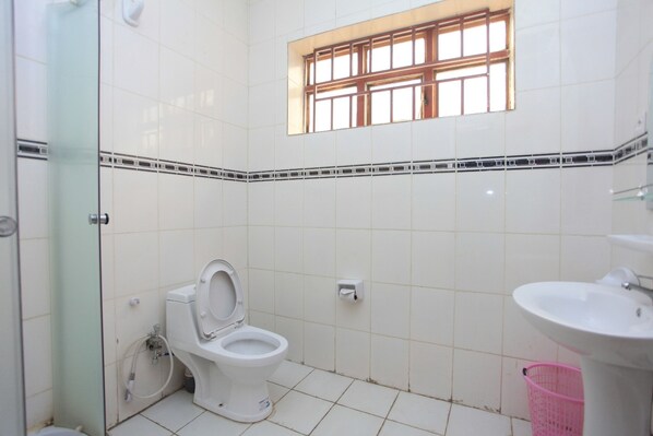 Un baño pequeño y limpio con inodoro, lavamanos y ventana.