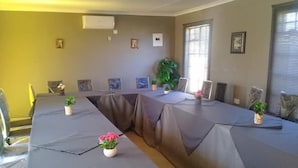 A conference room with a long table, chairs, and small potted plants. - Kutse Guesthouse (Letlhakeng)