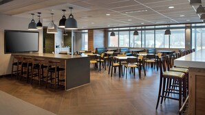 A modern restaurant with a long counter, multiple seating areas, and pendant lighting. - Fairfield Inn & Suites by Marriott Williamstown (Williamstown)