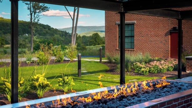 A fire feature with a metal frame and a brick wall in the background. - Fairfield Inn & Suites by Marriott Williamstown (Williamstown)