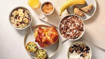 Un petit-déjeuner composé de porridge, d’un muffin, d’un croissant et d’un bol de yaourt agrémenté de granola.