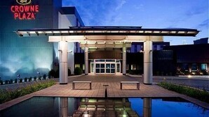 Un edificio moderno con un estanque reflectante en primer plano, que dice 