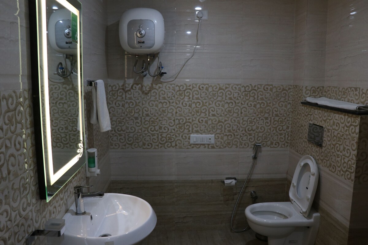 A bathroom with a sink, toilet, and a wall-mounted heater.