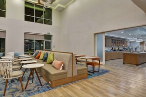 A modern hotel lobby with a seating area, a kitchen, and a staircase. - Homewood Suites by Hilton Chula Vista-Eastlake (Chula Vista)