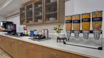 A buffet area with a coffee station, cereal dispensers, and a coffee maker.