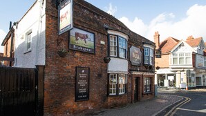 A traditional brick building with multiple signs advertising local food, cask ales, and en-suite rooms. - The Bull at Wargrave (Reading)