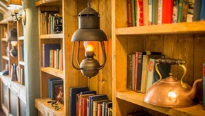A bookshelf with books and a hanging lantern. - The Bull at Wargrave (Reading)