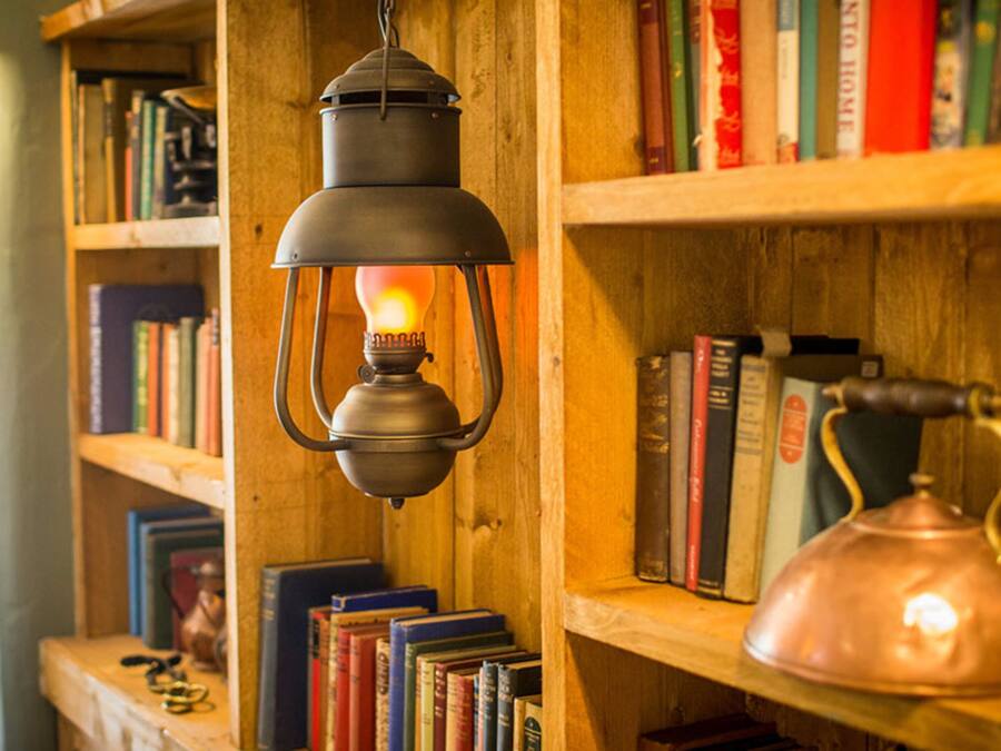 Ein Bücherregal mit Büchern und einer hängenden Laterne.
