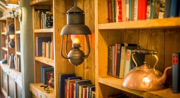 A bookshelf with books and a hanging lantern.