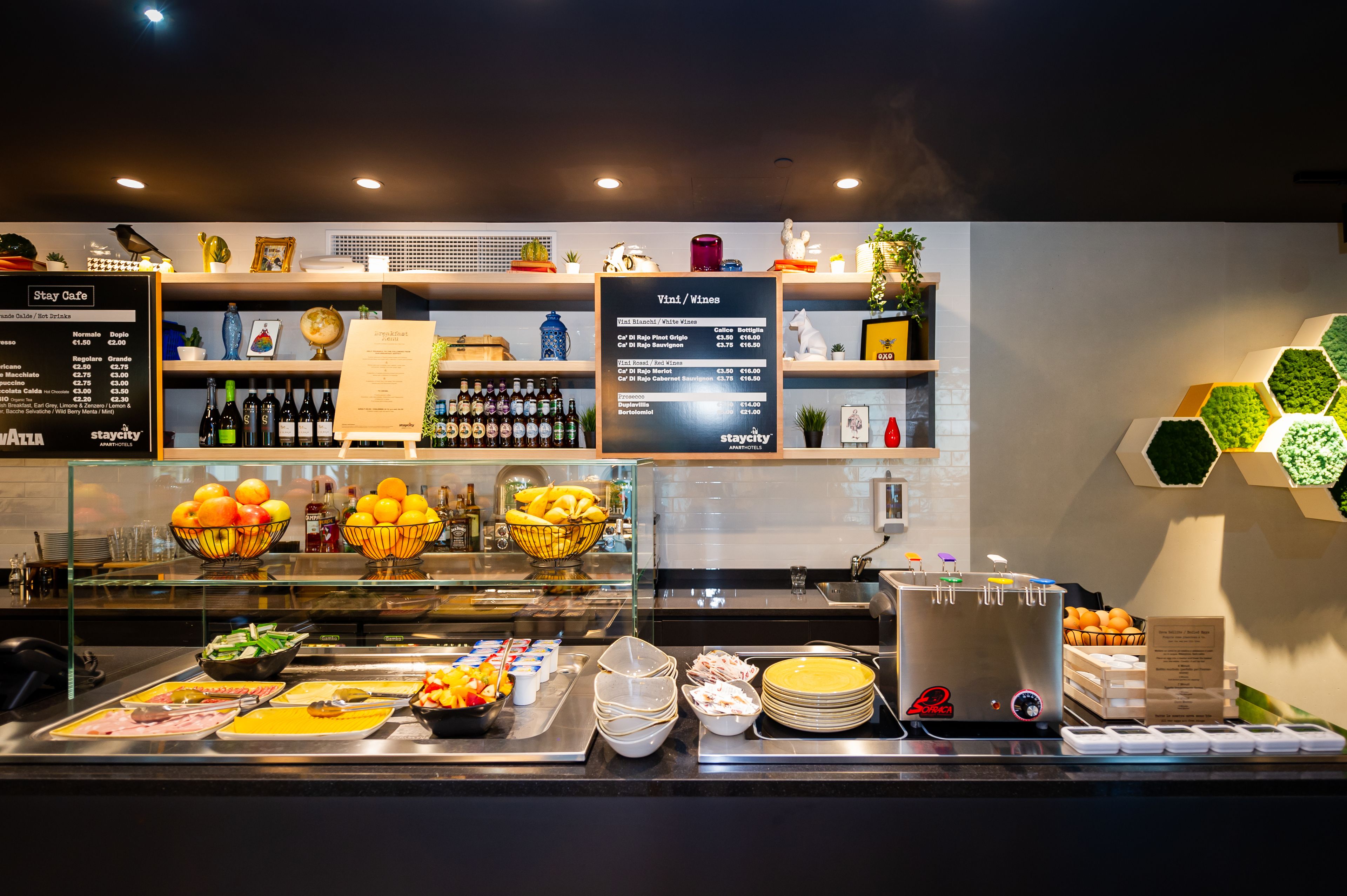A buffet area with various food items, a wine menu, and a selection of beverages.
