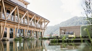 A wooden building with a balcony, a pool, and outdoor seating. - Hubertus Mountain Refugio Allgäu (Balderschwang)