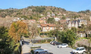 A residential area with houses on a hillside, a parking lot with cars, and a clear sky. - Bidaia Boutique Hotel (San Sebastián)